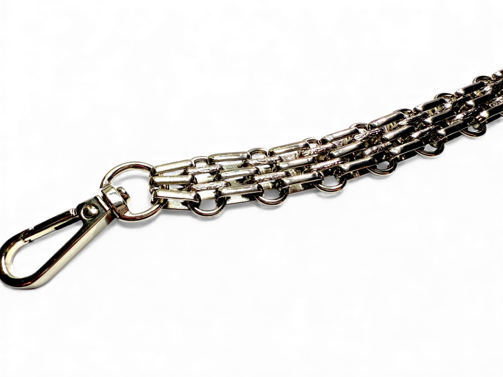 Close up view of the silver, multi row, link chain, bracelet style bag strap