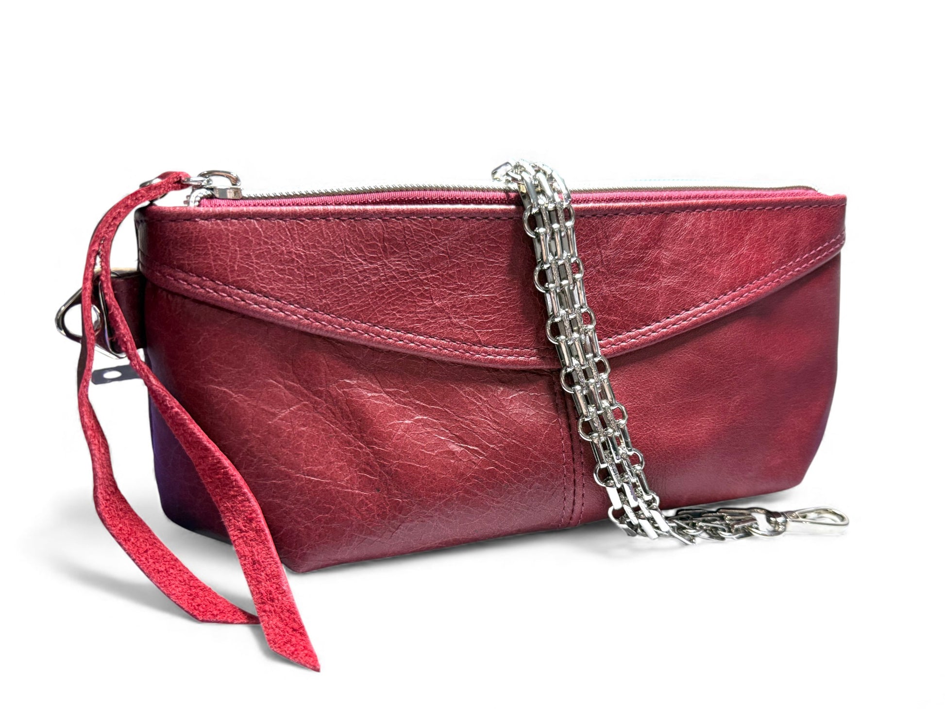 Red leather clutch bag with the multi row  silver chain strap, draped over it on a white background