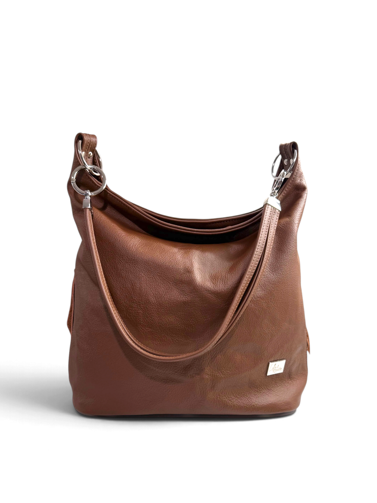 A brown leather hobo shoulder bag with silver-tone hardware and a small brand tag on the lower right front, photographed on a clean white background.