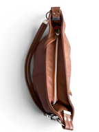 A brown leather slouchy handbag shown from an angled top-down view, featuring a silver zipper, a matching brown leather strap, and silver-tone metal hardware on a white background.