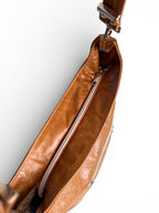Birds Eye view of the top of the tan coloured, genuine leather slouchy handbag, highlighting the zipper opening and the silver hardware