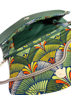 Interior view of a deep green handbag with colourful abstract patterned lining and chain detail on a white background. 