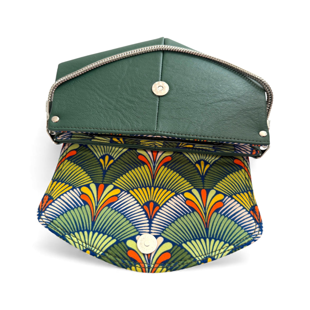 Green leather clutch with a colorful geometric pattern on a white background