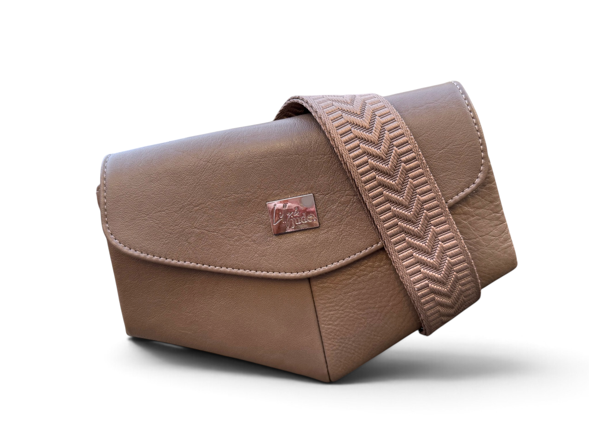 A mushroom brown leather shoulder bag with a matching chevron-patterned strap and a small metal brand plaque, shown on a white background.