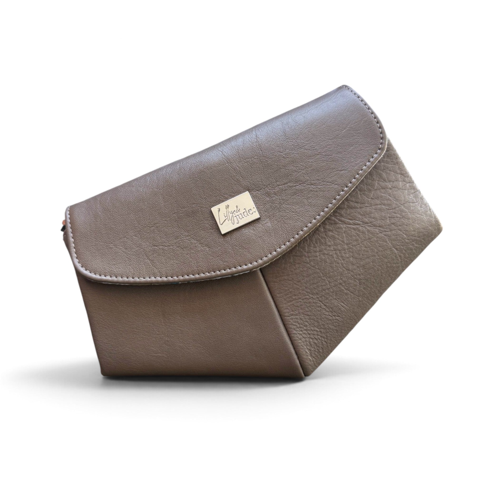 A taupe brown leather clutch bag with a small silver-tone metal Lilly & Jude logo plaque on the front flap, set against a plain white background.