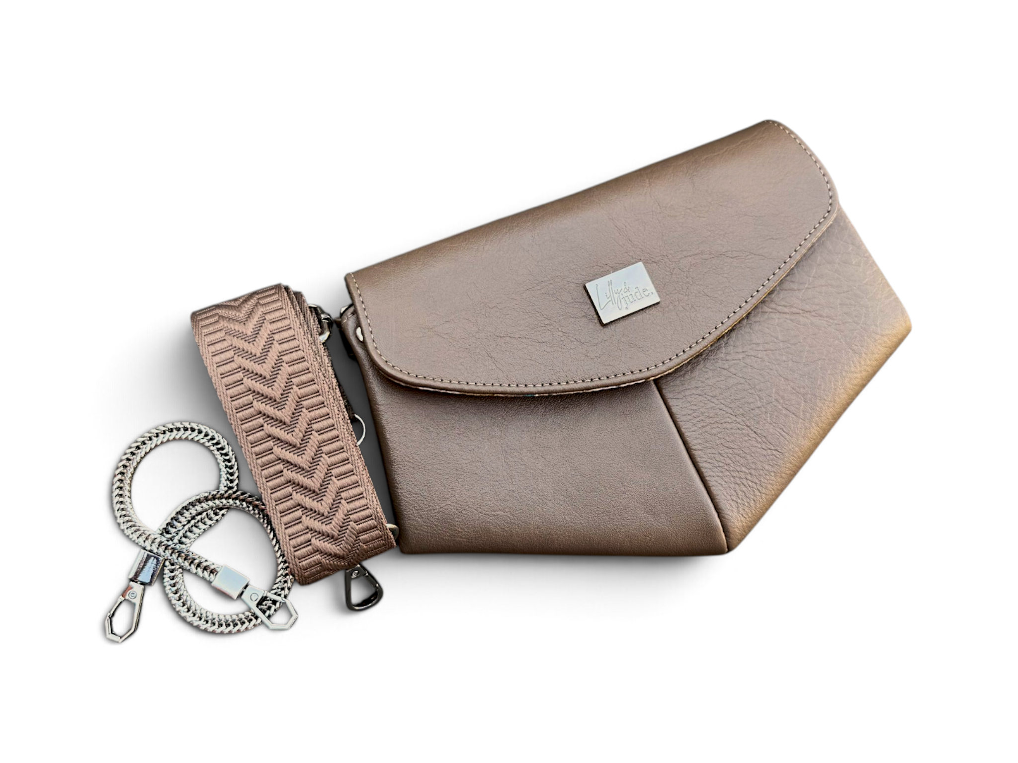 A taupe coloured leather clutch bag with a matching patterned crossbody strap and a silver chain link wrist strap, displayed on a clean white background.