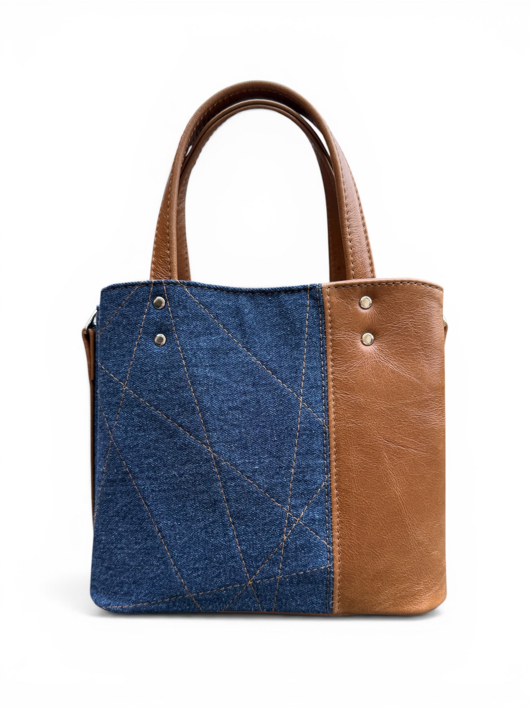 Rear view of the Soraya handbag with blue denim and tan brown leather design on a white background