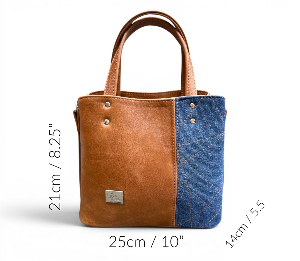 Tan brown leather and denim blue tote bag with measurements on a white background