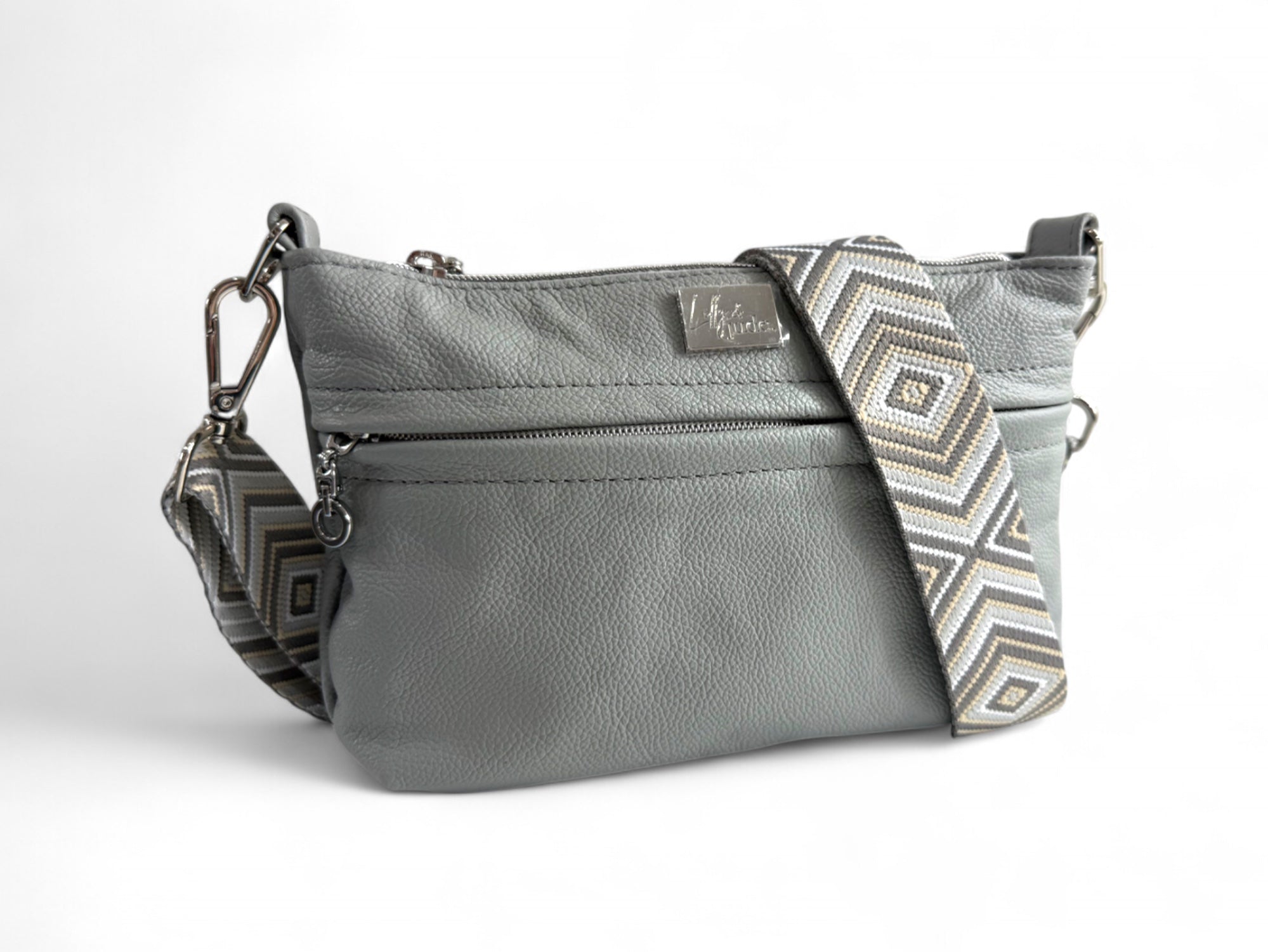 Genuine grey leather Starburn handbag with geometric patterned strap on a white background
