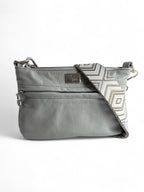 A light grey leather crossbody bag with a geometric pattern on the strap and silver hardware.