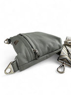 View of the Starburn crossbody bag with patterned strap and silver hardware, lying down on a white background