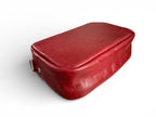 View of the bottom of the Tiny Harriet crossbody, handmade from red leather on a white background