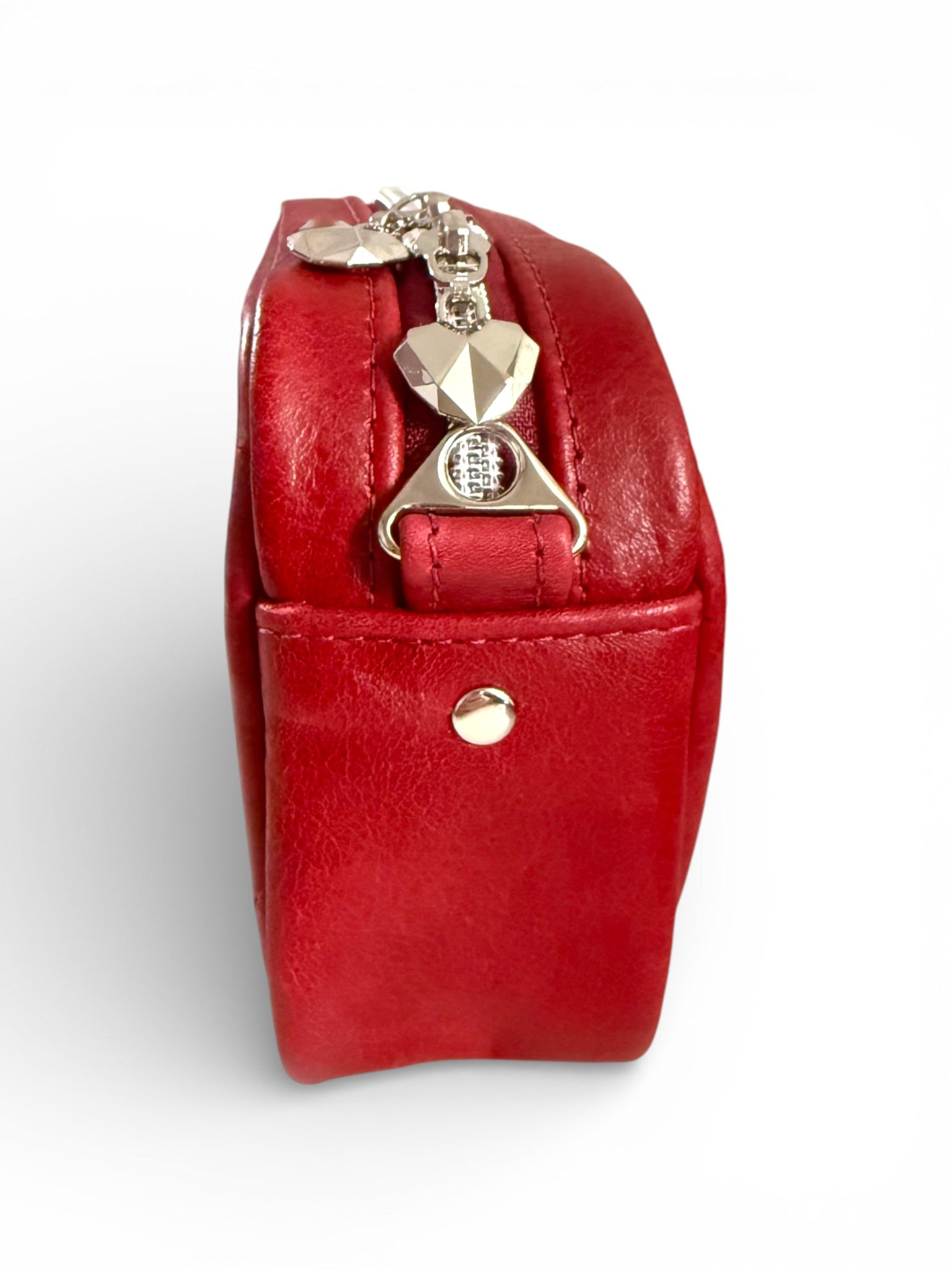 Side view of the Tiny Harriet, small crossbody bag, highlighting the silver hardware and geometric heart shaped zipper pulls