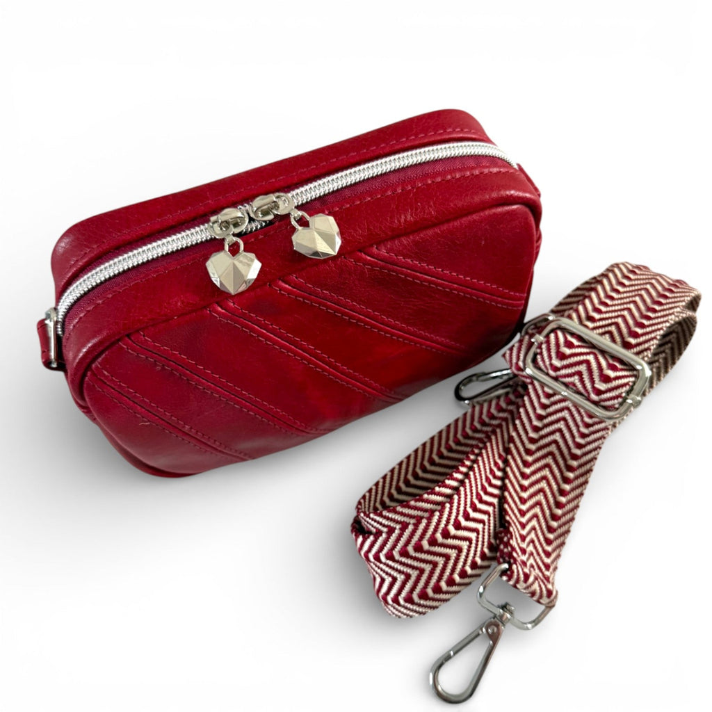 Hand crafted, red genuine leather crossbody bag with a matching strap on a white background