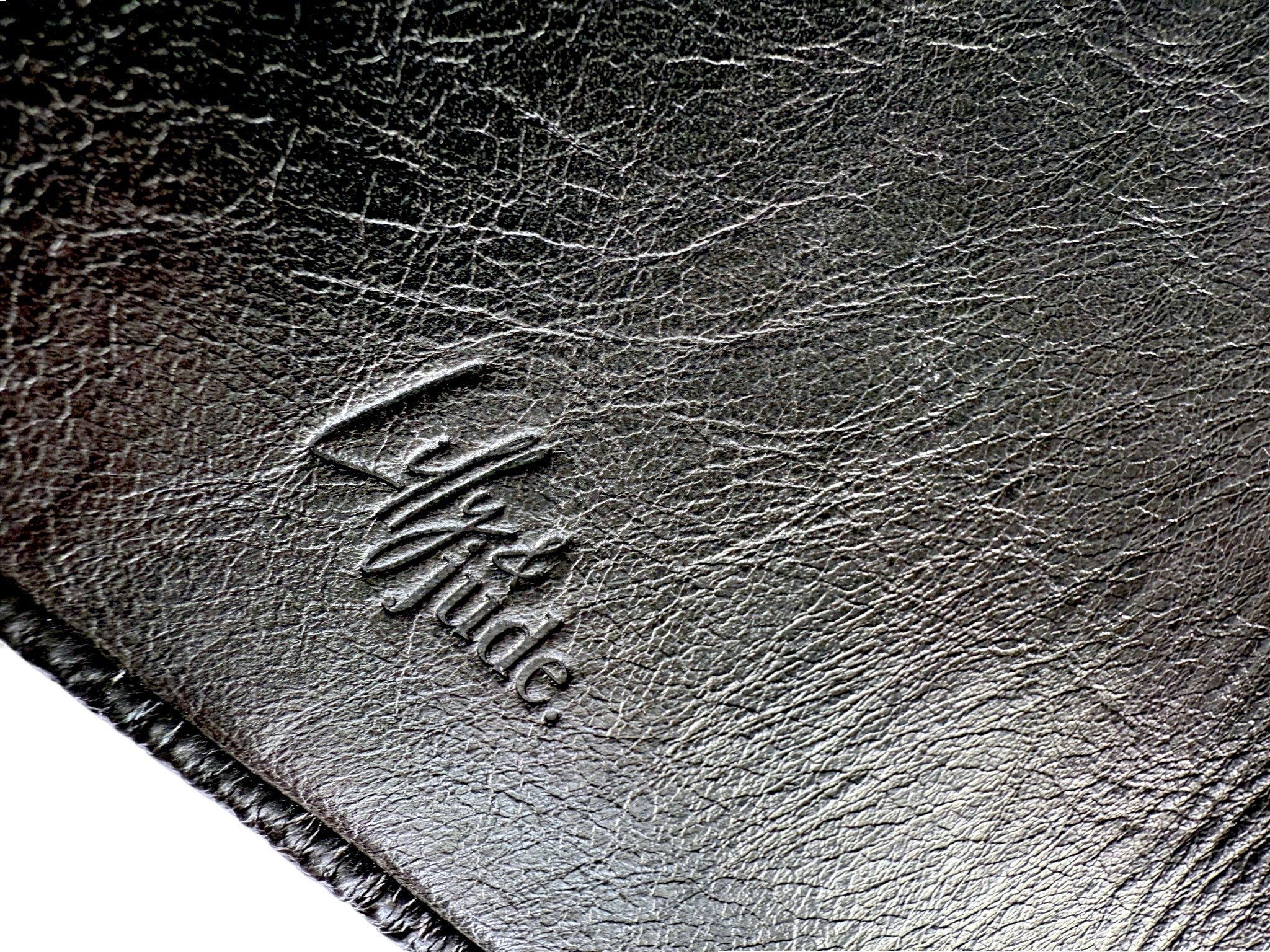 Close-up of a textured leather surface with a brand logo embossed on it.