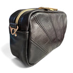 Black leather panelled bag with gold zipper and clasp on a white background