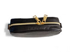 Compact, black leather bag with gold zipper on a white background