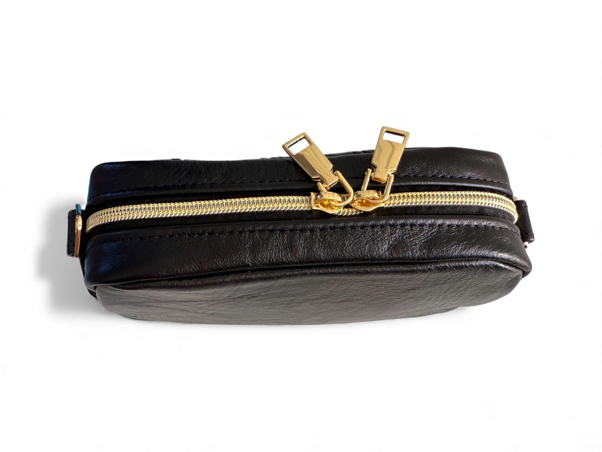 Compact, black leather bag with gold zipper on a white background