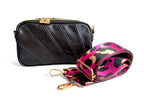 Small black leather crossbody bag with a pink and black leopard print strap on a white background