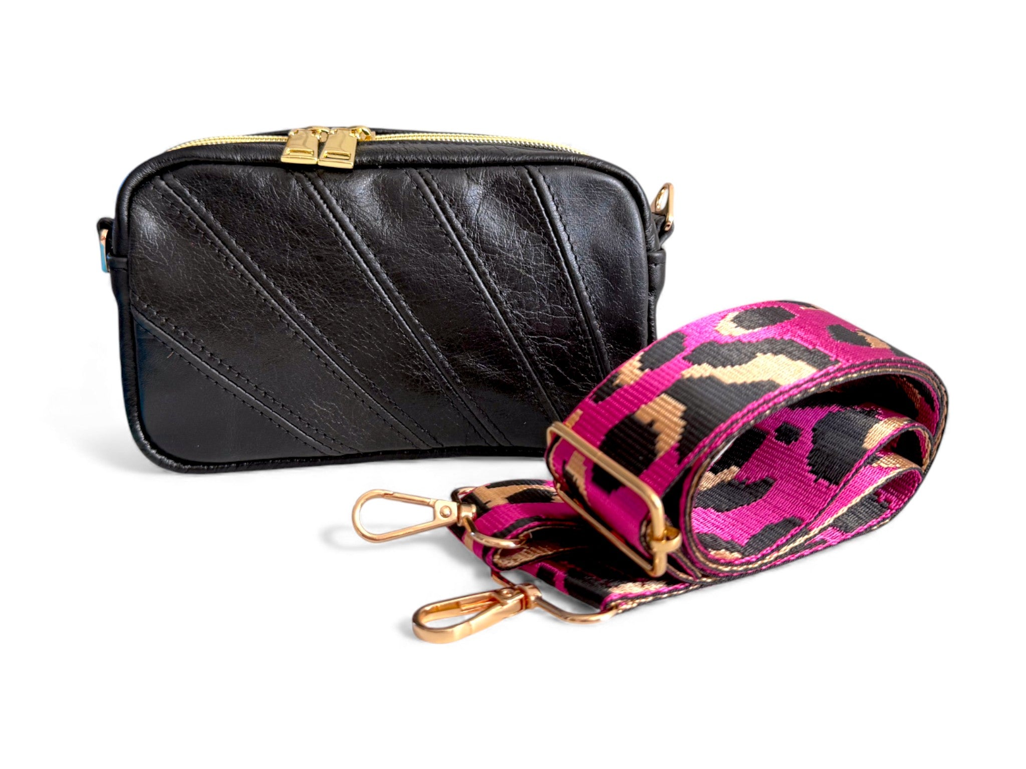 Small black leather crossbody bag with a pink and black leopard print strap on a white background