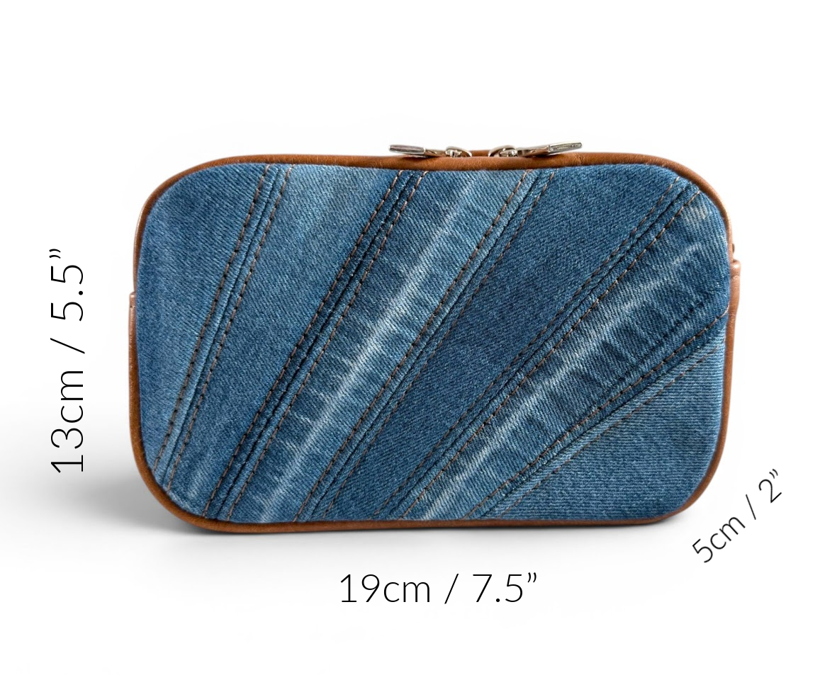 Blue denim and tan leather compact crossbody bag with measurements annotated around the edge, on a white background