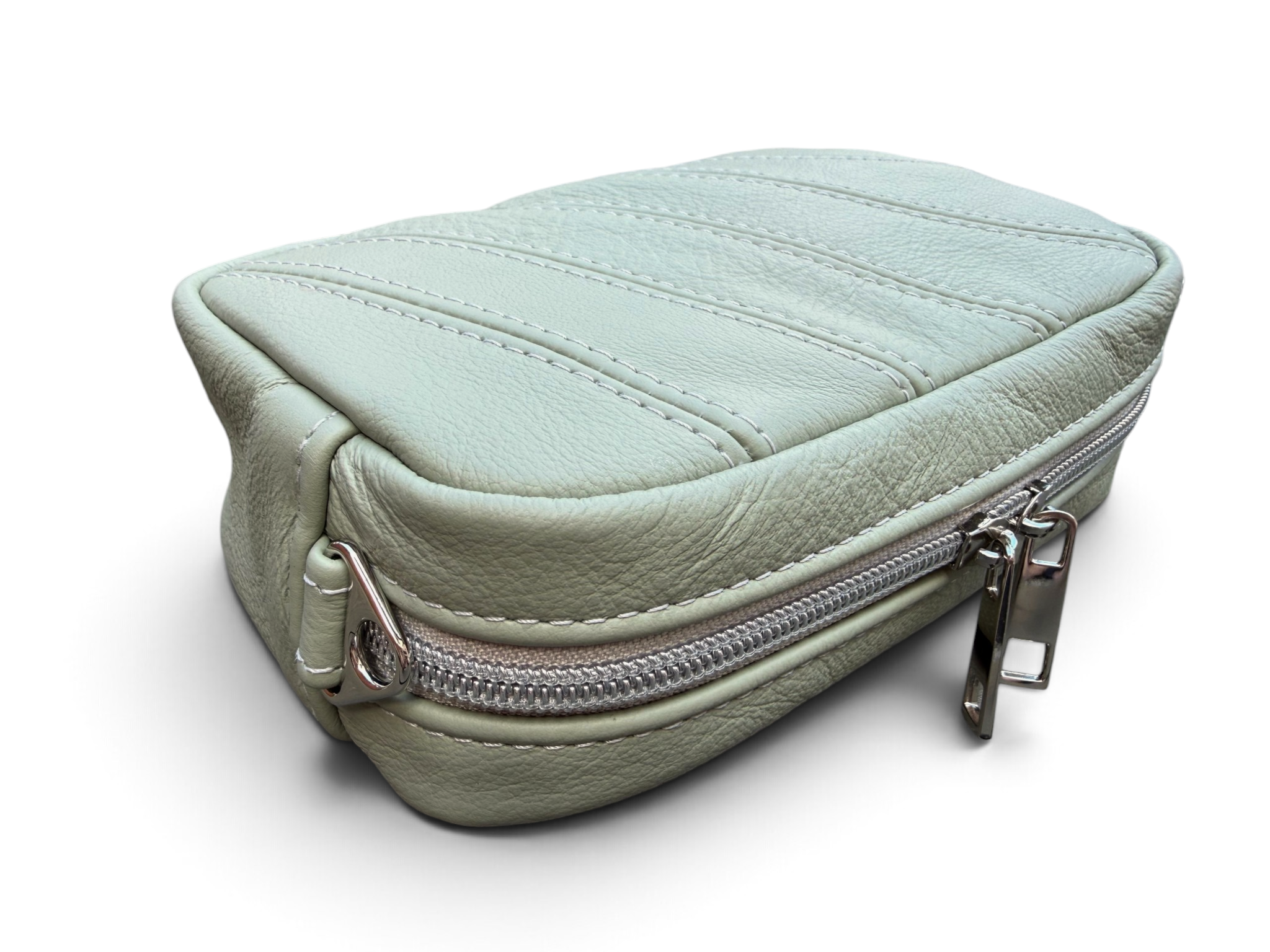 A light sage green pebbled leather zippered pouch with silver metal hardware, shown on a clean white background.