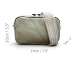 A small rectangular crossbody bag in light sage green with diagonal stitched paneling and a wide woven strap, shown on a white background with overlaid dimensions: 13cm / 5.5" height, 19cm / 7.