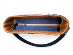 Birds eye view of the Veronica handbag, showing the tan leather interior facing and the denim zipper placket, sat on a white background
