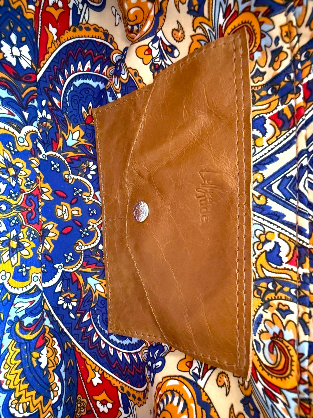 Tan leather integrated purse on a colourful patterned lining 