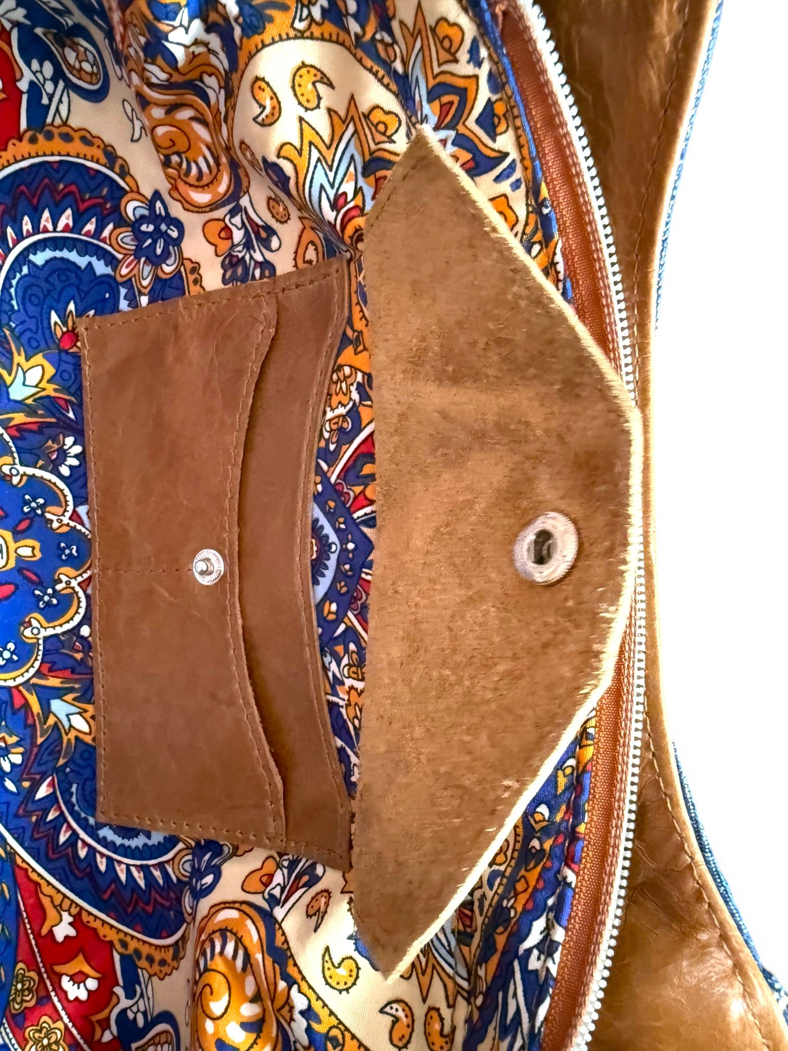 Interior view of the Veronica handbag, showing a close-up of the leather integrated purse and a colorful patterned fabric lining