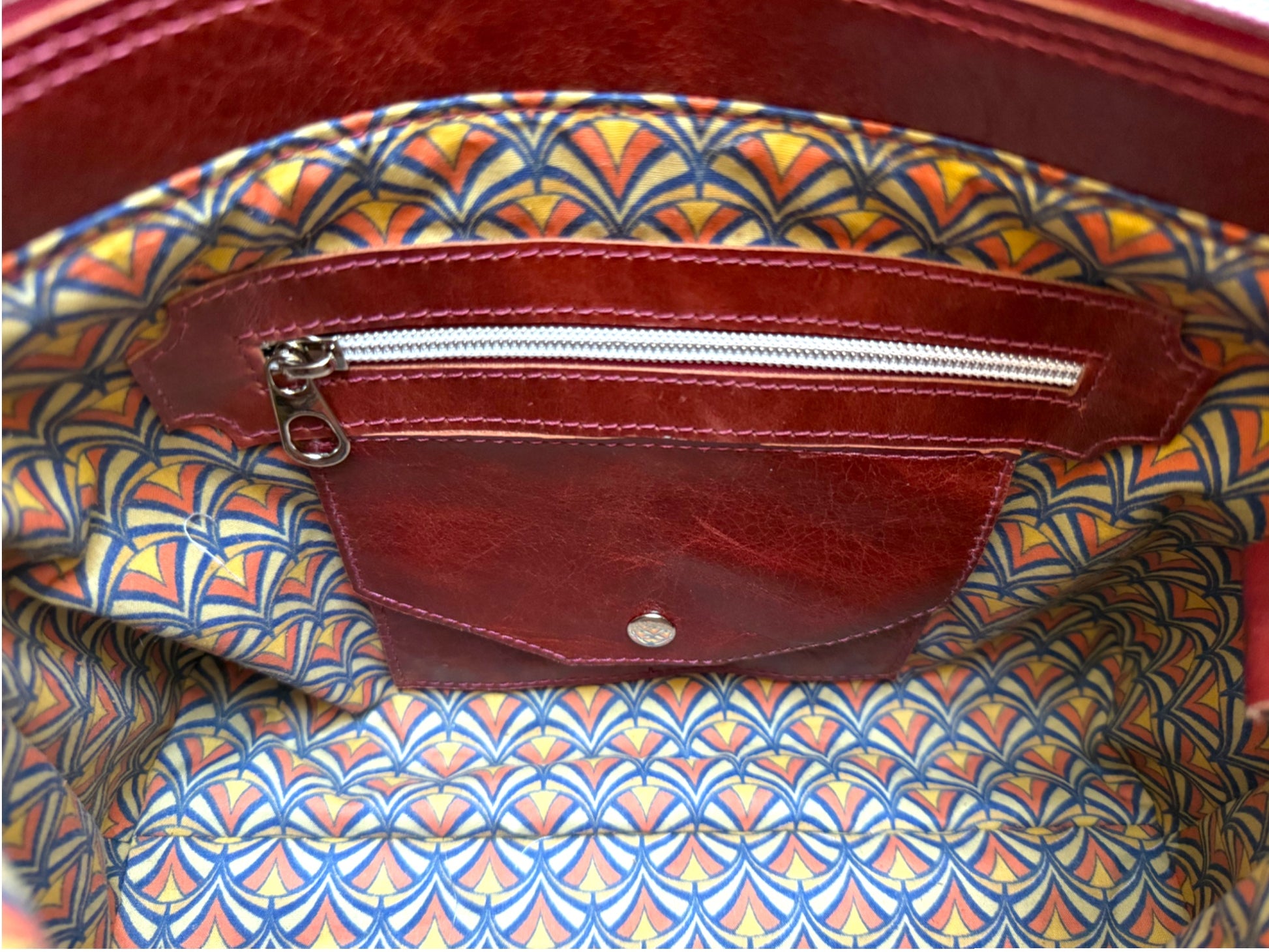 Interior view of the Alaula handbag, showing signature integrated leather purse and the secure zip pocket. 
