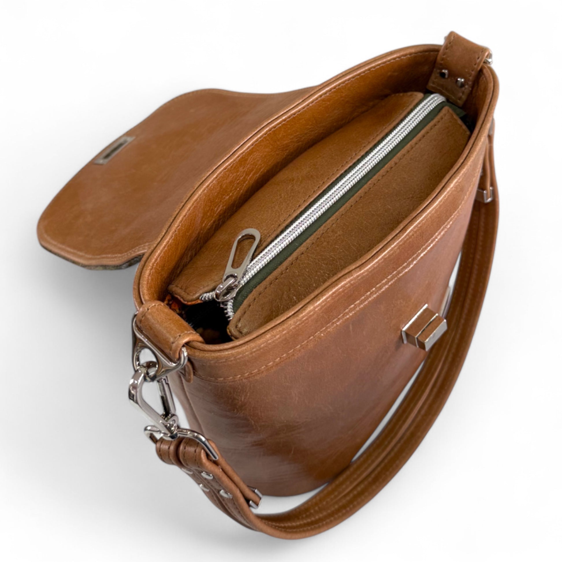 Top view with flap open showing the zipper opening of the Belle bucket bag. It is stood on a plain white background

