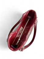 Birds Eye view of dark red, rescued leather Alaula handbag and silver hardware on a white background