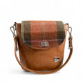 Tan leather bucket handbag with autumn-toned tweed panels against a plain white background