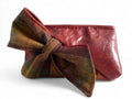 Red leather pouch with a plaid bow on a white background