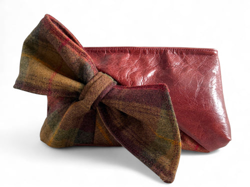 Red leather pouch with a plaid bow on a white background