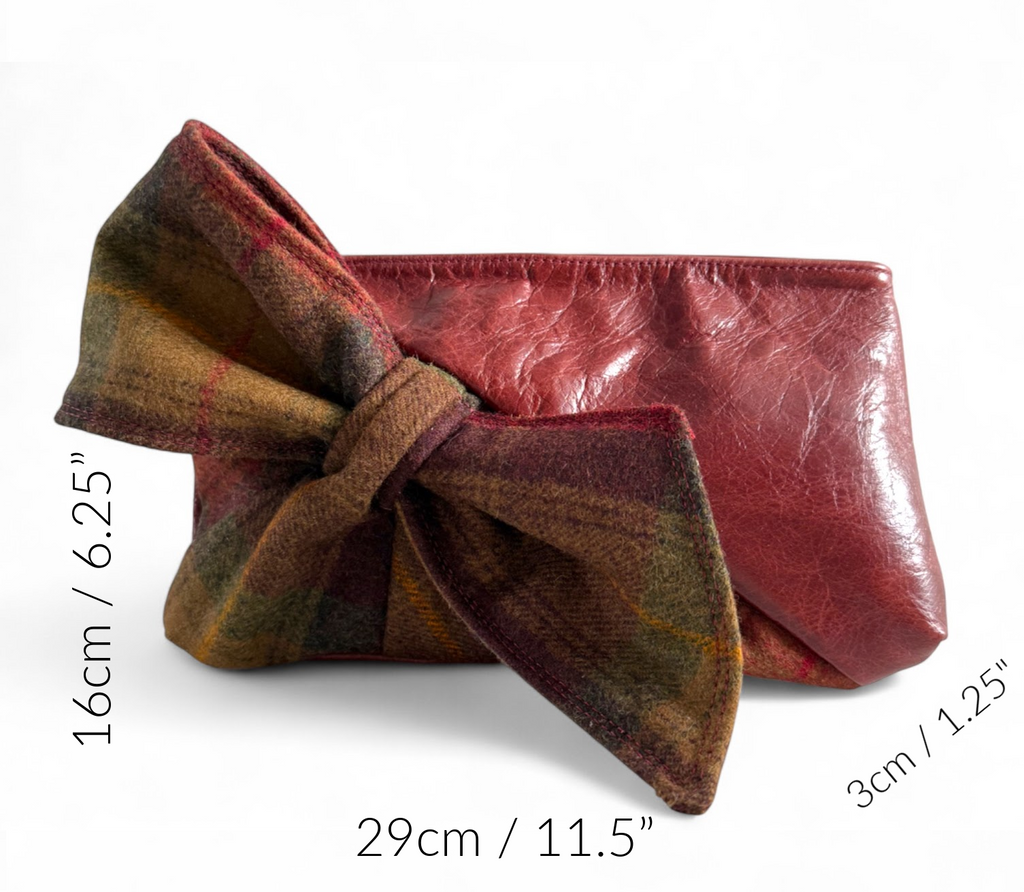 Burgundy leather and plaid woollen tweed bow clutch bag against a white background and measurements of the dimensions of the bag