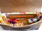 Open brown leather handbag with floral interior lining. 