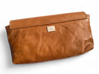 View of the back of the tan leather Bronte clutch bag, highlighting the Lilly & Jude logo tag.