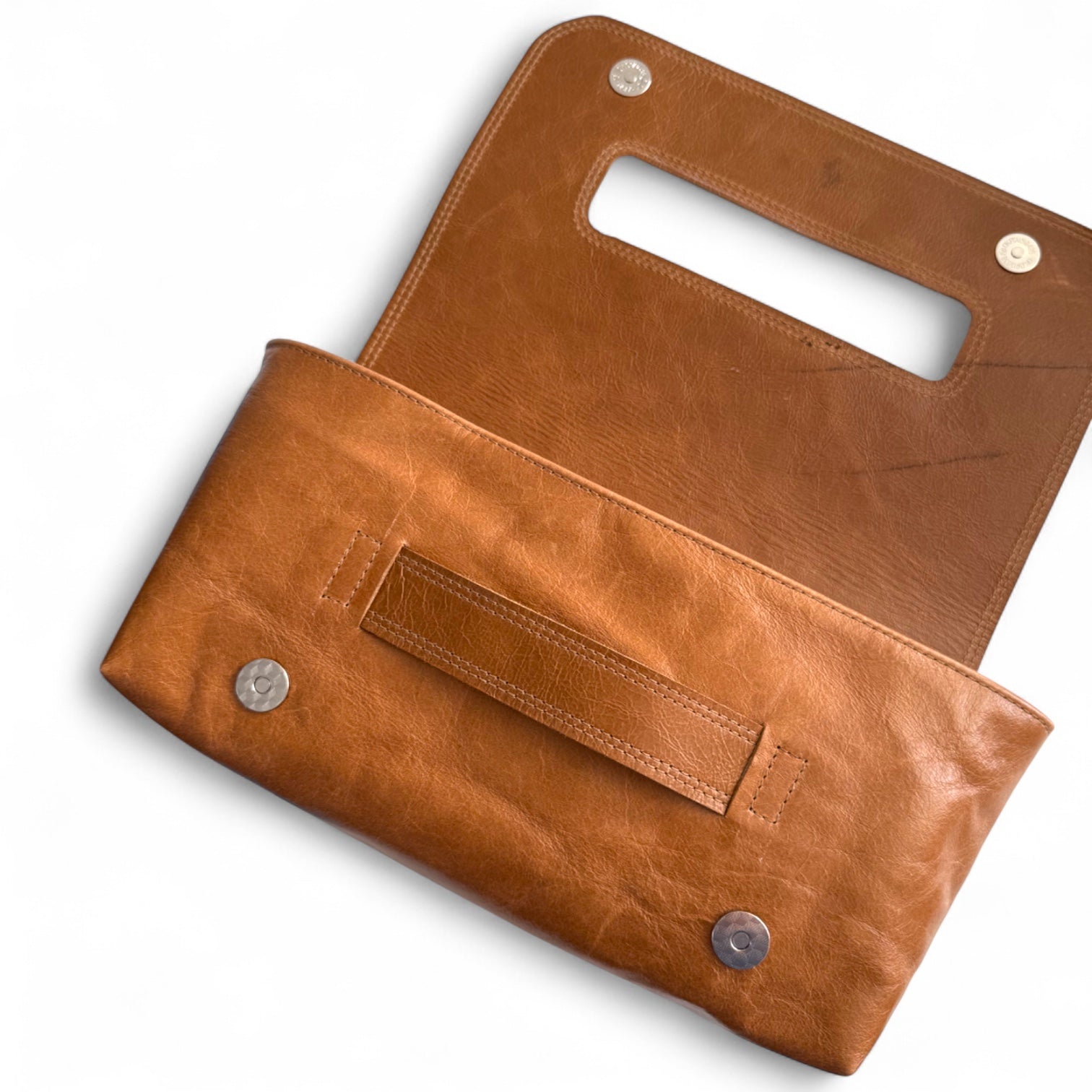 Tan Bronte clutch bag, lying down on a white background with the flap lying open. The image shows the scarring and texture on the leather, which was rescued from heading to landfill 