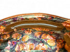 Floral-patterned bag lining with a zipper on a white background. Interior view of leather East / West Handbag