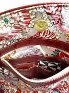 View of the paisley patterned lining and integrated leather wallet with money and card visible.