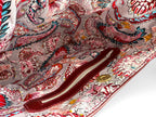 Close-up of a colorful paisley patterned lining of a burgundy leather slouch handbag, highlighting the interior zipper pocket