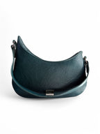 Teal, genuine leather, asymmetric style designer handbag on a white background