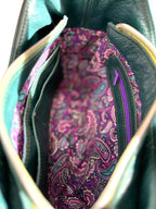 Close-up of a purple paisley fabric lining inside the teal coloured Faye leather bag.