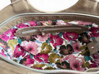 View of the floral interior lining of the taupe leather Flossy bag, with leather trimmed interior zipper pocket.
