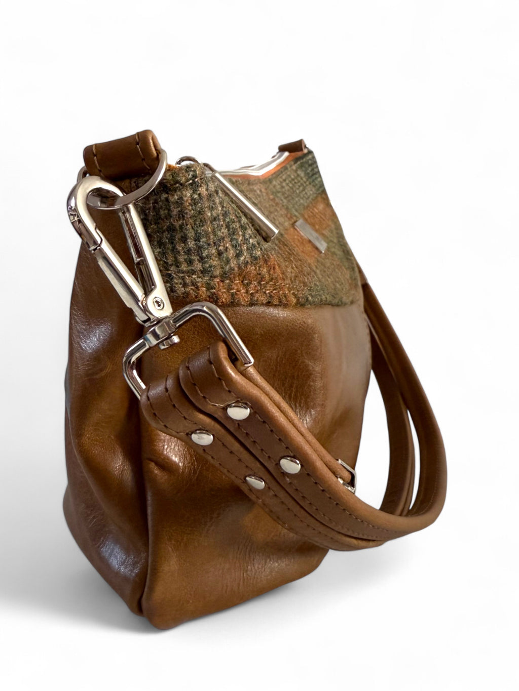 Brown leather handbag with a woollen tweed and silver buckle on a white background