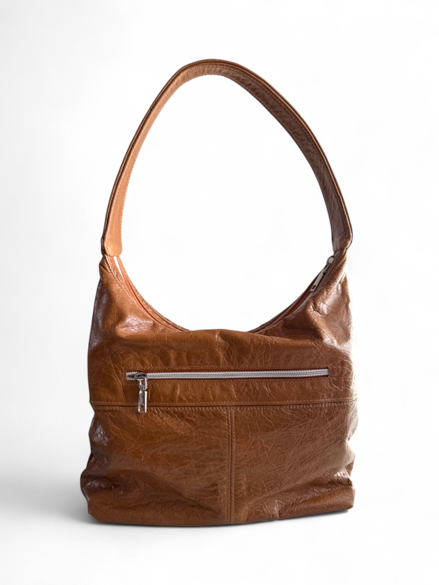 View of a tan brown leather slouchy handbag with a silver zipper on a white background