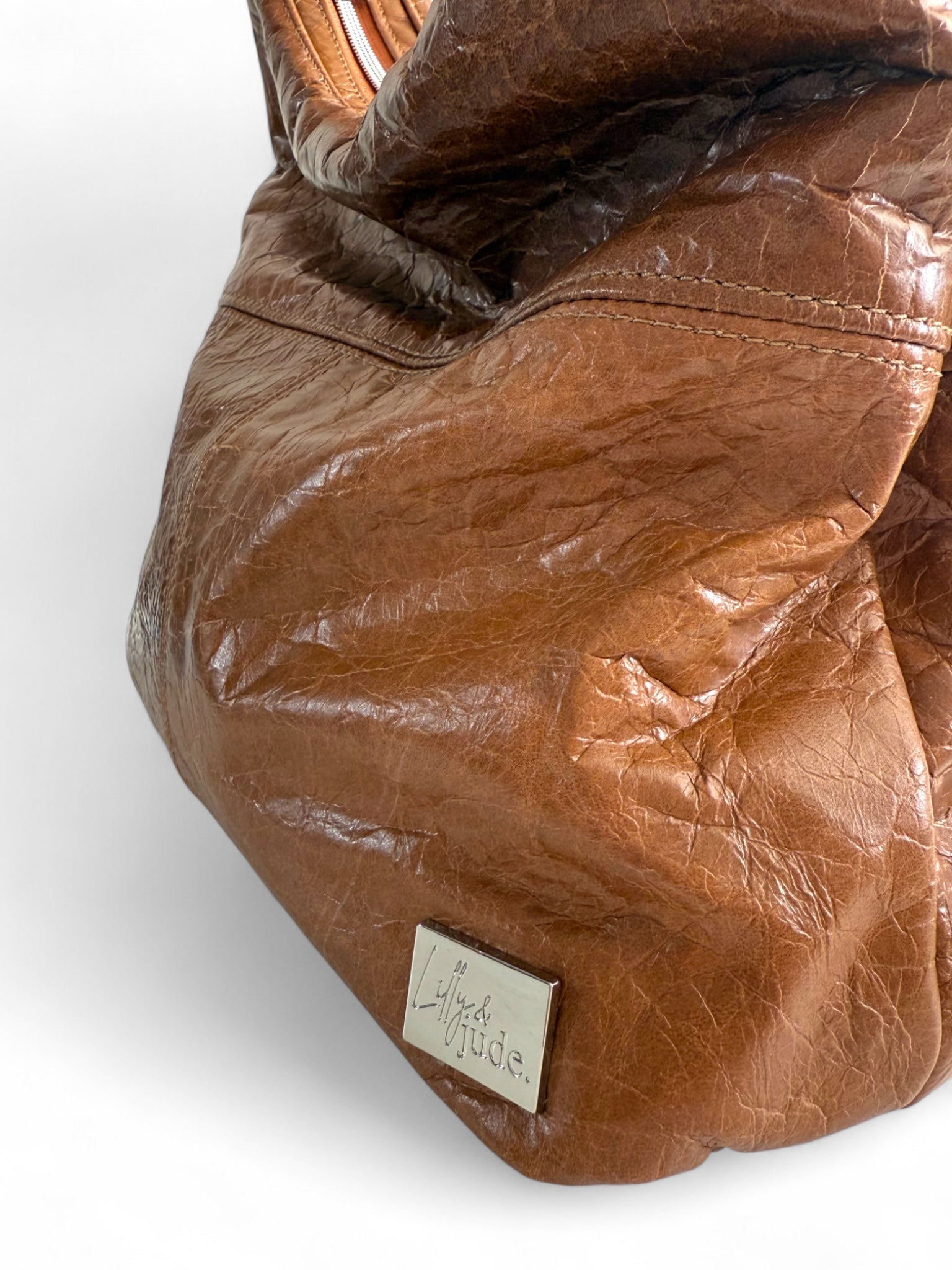 Tan brown leather bag with a visibleLilly & Jude label on a white background