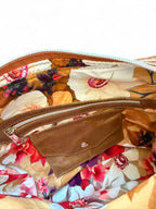 Floral-patterned bag with a brown leather pocket purse and zipper.